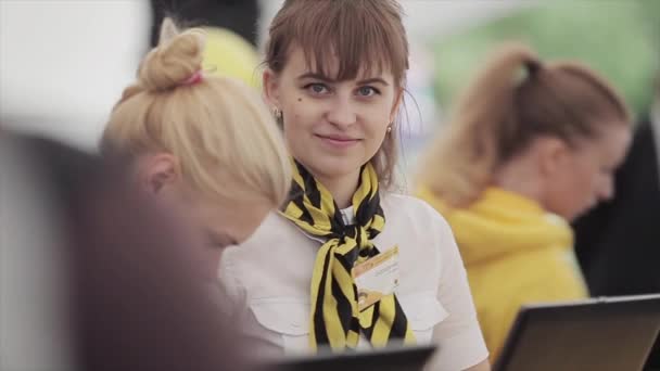 圣彼得堡，俄罗斯 - 2015年7月16日：女孩在黑色和黄色披肩微笑，挥手在相机在夏季节日。娱乐。阳光 — 图库视频影像