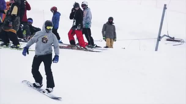 SOCHI, RUSIA - 29 DE MARZO DE 2016: Paseo en snowboard desde la ladera de las montañas nevadas. Concurso. Estación de esquí. Gente. Deporte extremo . — Vídeo de stock