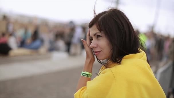 SAN PETERSBURG, RUSIA - 16 DE JULIO DE 2015: Una joven cubierta de manta amarilla quitó el pelo de la cara en el festival de verano. Día soleado. Entretenimiento . — Vídeos de Stock