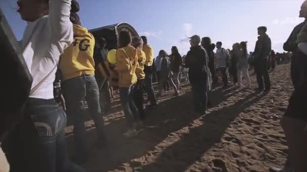 SAINT PETERSBURG, RÚSSIA - 16 de julho de 2015: Multidão de pessoas animadas no festival de verão no palco na areia. Dia ensolarado. Entretenimento. Capuz amarelo — Vídeo de Stock