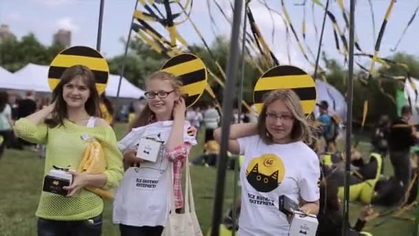 圣彼得堡，俄罗斯 - 2015年7月16日：三个少女与圆形的黑色和黄色板在头摆姿势在夏季节日。娱乐 — 图库视频影像