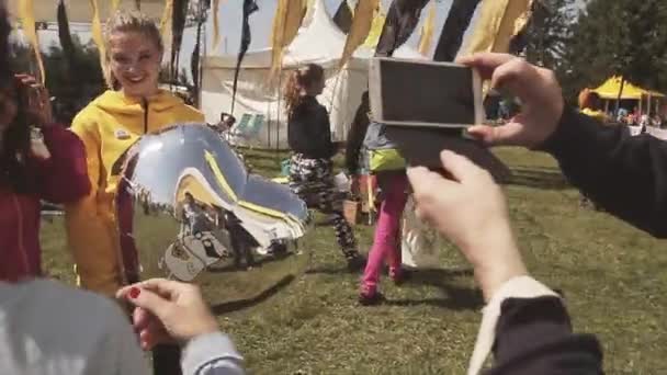SAN PETERSBURG, RUSIA - 16 DE JULIO DE 2015: Dos chicas posando en cámara con globo aerostático, sonríen. Festival de verano. Soleado. Fotógrafo. Banderas — Vídeo de stock