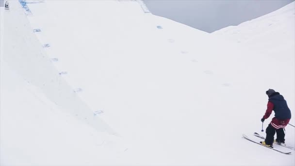 Sotsji, Rusland-29 maart 2016: skiër in uniform sprong van Springplank. Extreme stunt. Besneeuwde bergen. Uitdaging. Landschap — Stockvideo