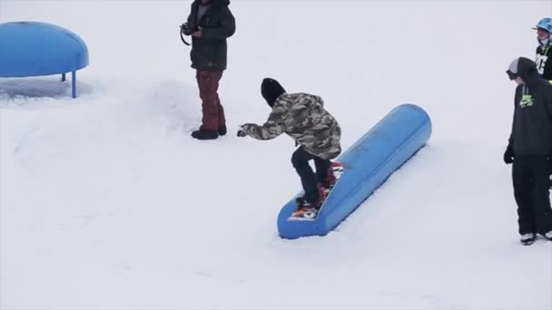SOCHI, RUSIA - 29 DE MARZO DE 2016: Salto snowboarder en kicker en la estación de esquí en las montañas. Un hobby extremo. Gente. Trucos. Camarógrafo — Vídeos de Stock