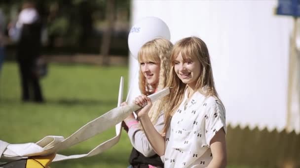 SAINT PETERSBURG, RUSSIE - 16 JUILLET 2015 : Deux filles blondes prennent des bottes d'énormes chaussures de sport noires et jaunes. Poser pour la photo. Festival d'été — Video