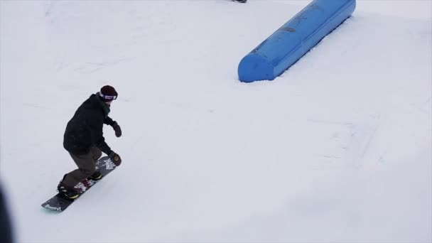 SOCHI, RUSSIA - 29 MARZO 2016: Scivolo snowboarder su kicker, salto alla stazione sciistica. Montagne innevate. Sport estremi. Gente. acrobazie — Video Stock