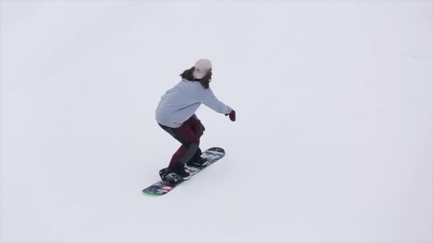 SOCHI, RUSIA - 29 DE MARZO DE 2016: Snowboarder jump, touch kicker by one leg at ski resort in mountains. Extremadamente. Trucos. Camarógrafo — Vídeo de stock