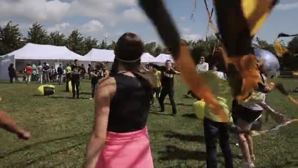 상트 페테르부르크, 러시아 - 7 월 16, 2015 : 사람들이 검은 색과 노란색 테이프를 흔들며 녹색 공원에서 여름 축제에 춤을. 엔터테인먼트. — 비디오