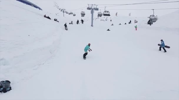 Sochi, Rusko-29. březen 2016: jízda snowboardista na odrazový můstek v lyžařském středisku v horách, neuspěje. Extrémní kaskadéra. Výzva. Lidé — Stock video