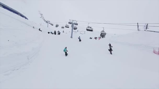 СОЧИ, РОССИЯ - 29 марта 2016 года: Поездка на сноуборде по трамплину на склоне. Лыжный курорт в горах. Вызов. Шлем. Лыжные подъемники — стоковое видео