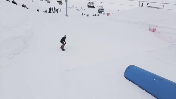 SOCHI, RUSSIE - 29 MARS 2016 : toboggan snowboard au tremplin de la station de ski en montagne. Extrême retournement. Caméraman. Les gens — Video