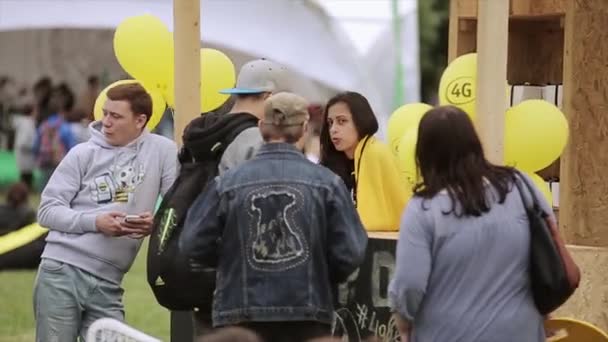 상트 페테르부르크, 러시아 - 7 월 16, 2015 : 젊은 사람들이 여름 축제에 노란색 공기 풍선, 소녀와 함께 서 있다. 써니. 엔터테인먼트 — 비디오