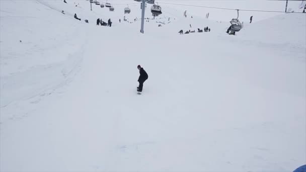 СОЧИ, РОССИЯ - 29 марта 2016 года: Поездка на сноуборде по трамплину на склоне. Лыжный курорт в горах. Вызов. Посетители. Лыжные подъемники — стоковое видео