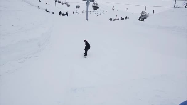 Sochi, Ryssland - den 29 mars 2016: Snowboardåkare rida på springboard på slutta. Skidorten i bergen. Utmaning. Besökare. Skidliftar — Stockvideo