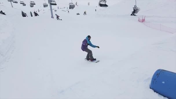 SOCHI, RUSIA - 29 DE MARZO DE 2016: Snowboarder saltar en el trampolín, agarrar el aire en la pendiente. Estación de esquí en las montañas. Desafío. Gente . — Vídeos de Stock