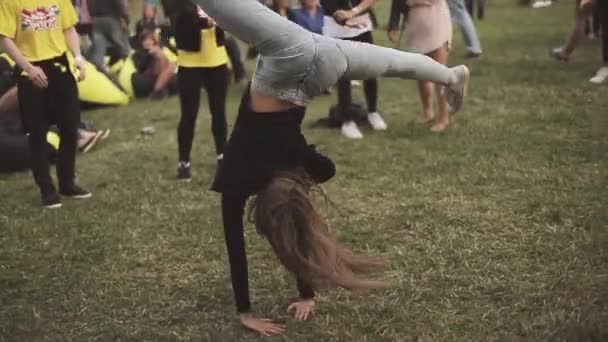 SANTO PETERSBURGO, RUSSIA - 16 LUGLIO 2015: Le ragazze fanno acrobatico flip sulle mani sull'erba sul festival estivo. Pubblico. Spettacolo . — Video Stock