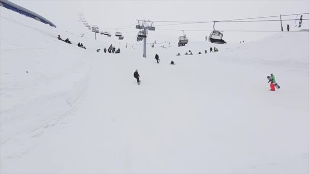 SOCHI, RUSIA - 29 DE MARZO DE 2016: Deslizamiento de snowboarder sobre trampolín en estación de esquí de montaña. Voltereta extrema. Remonte. Gente . — Vídeos de Stock