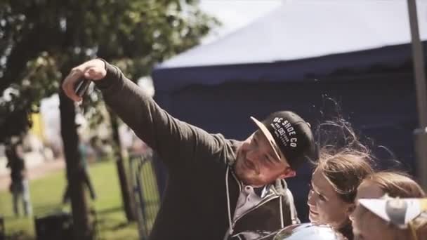 SAINT PETERSBURG, RUSSIA 16 JULY 2015: Man mengambil foto selfie dengan gadis-gadis remaja, anak laki-laki pada festival musim panas. Sunny. Hiburan. Spekular balon udara — Stok Video