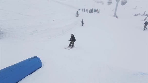 索契，俄罗斯 - 2016年3月29日：滑雪者从跳板在斜坡上跳跃，翻转。雪山滑雪胜地。挑战。雪 — 图库视频影像