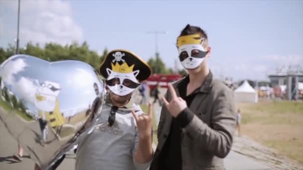 俄罗斯圣彼得堡 - 2015年7月16日：两名戴着滑稽面具的年轻人用水晶气球在镜头前摆姿势。夏季节日。人 — 图库视频影像