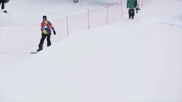 SOCHI, RUSIA - 29 DE MARZO DE 2016: Salto snowboarder sobre pateador en estación de esquí en las montañas. Deporte extremo. Gente. Trucos. Camarógrafo — Vídeo de stock