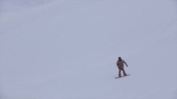 SOCHI, RUSSIA - 31 MARZO 2016: Lo snowboarder sul pendio fa un salto estremo in alto nell'aria in montagna innevata. Concorso. Sfida . — Video Stock