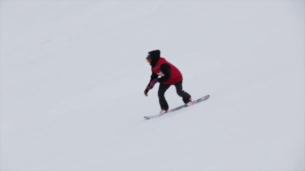 СОЧИ, РОССИЯ - 31 марта 2016 года: Сноубордист совершает прыжок в высоту с трамплина в снежной горе. Каскадер. Задача . — стоковое видео