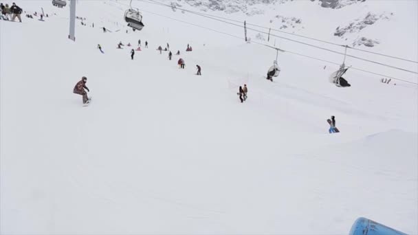 SOCHI, RÚSSIA - 31 de março de 2016: Passeio de snowboarder no trampolim, acrobacia. Paisagem. Montanhas nevadas. Concurso. Extremo. Cameraman — Vídeo de Stock