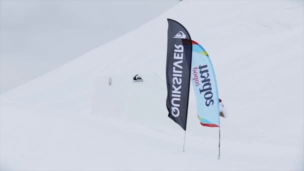 СОЧИ, РОССИЯ - 31 марта 2016 года: Лыжник делает экстремальное кувыркание в воздухе, прыгает с трамплина. Пейзаж снежных гор. Конкурс . — стоковое видео