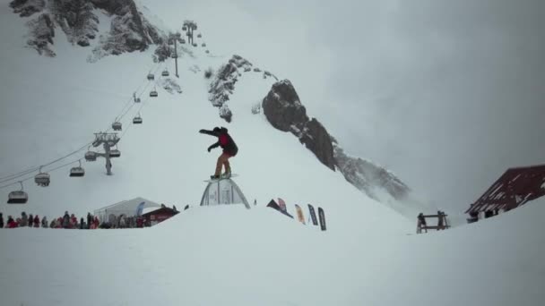 Sotschi, Russland - 31. März 2016: Snowboarder fahren auf Eisenpfad im verschneiten Gebirge. Skigebiet. Menschen. Wettbewerb. Extremsport — Stockvideo