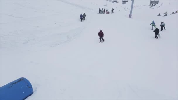 SOCHI, RUSIA - 29 DE MARZO DE 2016: Salto de esquiador y paseo en trampolín en la pendiente. Estación de esquí en montañas nevadas. Desafío. Nieve cae — Vídeos de Stock