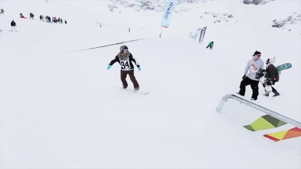 Soczi, Rosja - 31 marca 2016: Snowboardzista slajdów na szlak żelaza na stoku. Kamerzysta. Krajobraz z ośnieżonych gór. Konkurencji — Wideo stockowe