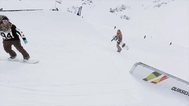 Sochi, Ryssland - 31 mars 2016: Snowboardåkare att glida på järn trail på sluttningen. Landskap. Snötäckta berg. Extrem sport. Tävling — Stockvideo