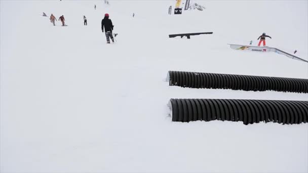 Soczi, Rosja-31 marca, 2016: Snowboarder jeździć na trampopokładzie, zrobić Stunt. Krajobraz. Śnieżne góry. Konkurs. Ekstremalne. Ośrodek narciarski — Wideo stockowe