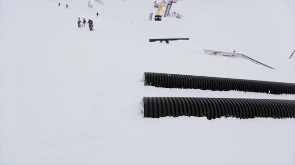 Sotschi, Russland - 31. März 2016: Snowboarder fahren auf Sprungbrett, machen Stunt. Landschaft. Schneebedeckte Berge. Wettbewerb. Extremer Flip. — Stockvideo