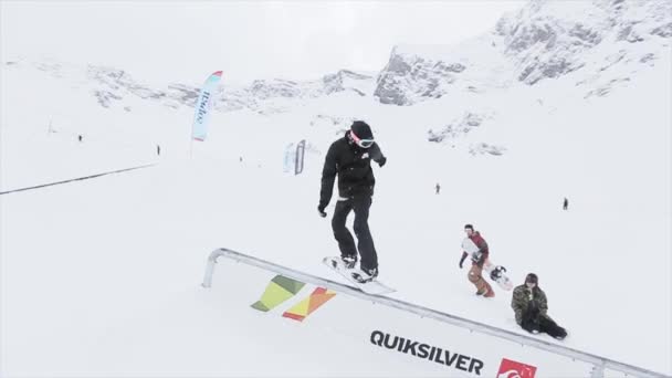 SOCHI, RUSSIA - 31 MARZO 2016: Scivolo snowboarder su pista in ferro sul pendio, ma fallire. Paesaggio di montagne innevate. Concorrenza . — Video Stock