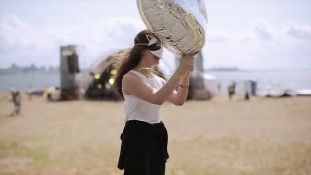 Sankt Petersburg, Ryssland-16 juli 2015: flicka i rolig mask med speglande luftballong hoppa på sommarfestival på stranden. Underhållning. Soliga — Stockvideo