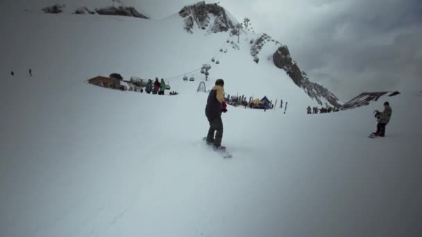 Sotschi, Russland - 31. März 2016: Snowboarderfahrt am Hang im schneebedeckten Berg. Blick in die Kamera. Skigebiet. Extremsport. Menschen — Stockvideo