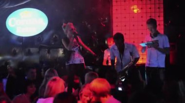 Saint Petersburg, Rusya - 27 Ağustos 2011: Adam saksafon mc kız, dj gece kulübünde sahnede tablet ile. Kırmızı ışık