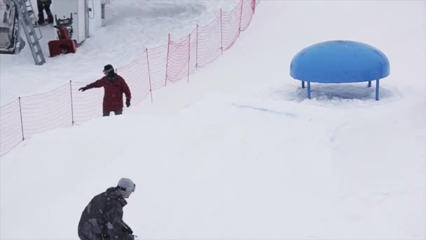 SOCHI, RUSIA - 29 DE MARZO DE 2016: Paseo de snowboard en kicker en la estación de esquí en las montañas. Deporte extremo. Gente. Trucos. Camarógrafo — Vídeos de Stock