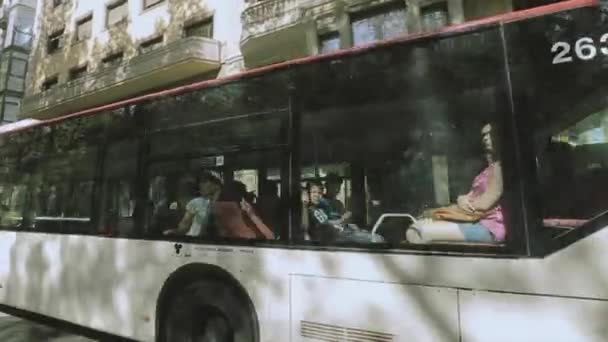 BARCELONA, ESPAÑA - 7 DE JUNIO DE 2015: Los niños saludan con las manos fuera del autobús. Día soleado de verano en la ciudad. Gente. Arquitectura — Vídeo de stock