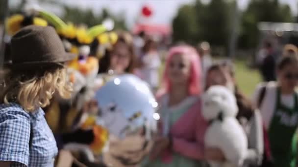 SAN PETERSBURG, RUSIA - 16 DE JULIO DE 2015: Las niñas se toman selfie con la chica de pelo rosa, hombre de traje de toro amarillo. Globo de aire. Festival de verano — Vídeo de stock