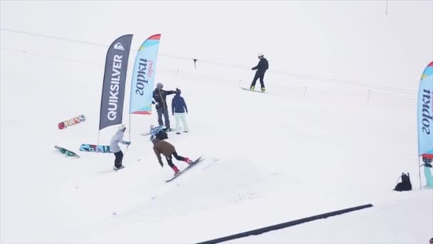 SOCHI, RUSSIA - 29 MARZO 2016: Snowboarder saltare dal trampolino di lancio, fare flip in aria. Montagne innevate. Concorso. Gente. Sport estremi — Video Stock