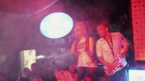 Sint-Petersburg, Rusland - 27 augustus 2011: Afroamerican man met saxofoon op het podium in nachtclub en mc meisje. DJ dans — Stockvideo