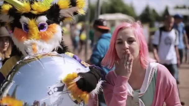 SAINT PETERSBURG, RÚSSIA - JULHO 16, 2015: Menina com cabelo rosa, homem de terno de touro amarelo com balão de ar. Festival de Verão. beijo de ar na câmara — Vídeo de Stock