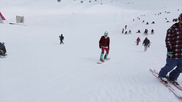 SOCHI, RUSIA - 31 DE MARZO DE 2016: Snowboarder se desliza por sendero de hierro en pendiente. Estación de esquí. Montañas nevadas. Competencia. Concurso — Vídeos de Stock