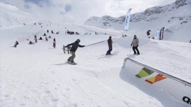 Soçi, Rusya - 31 Mart 2016: Snowboard yapmak aşırı döndürür, slayt yamaçta demir izinde. Manzara. Karlı dağ. Rekabet