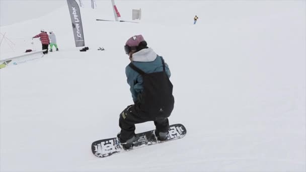 Sochi, Rusko - 31 března, 2016: Snowboardista make zpět snímek na železnou stezkou na svahu. Lidé. Zasněžené hory. Konkurence. Soutěž — Stock video