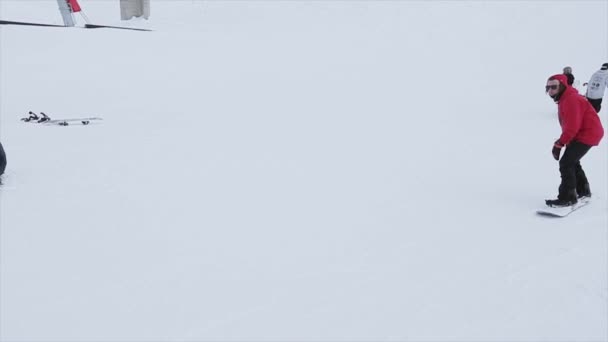 Sotschi, Russland - 31. März 2016: Snowboarder machen Rutsche auf Eisen-Trail. Landschaft. Schneebedeckte Berge. Wettbewerb. Wettbewerb. Kameramann — Stockvideo