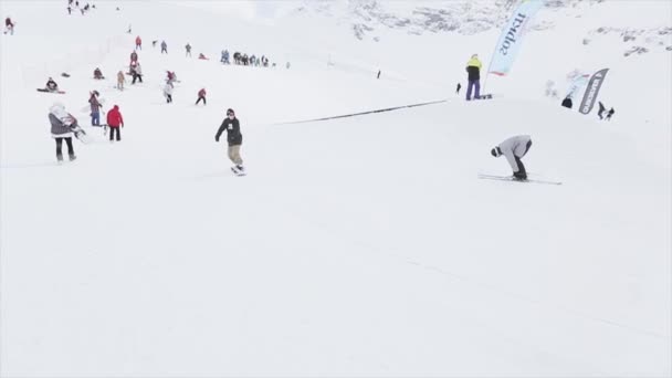 Сочі, Росія - 31 березня 2016: Сноубордист стрибок на залізо стежці на схилі, зробити слайд. Оператор. Снігові гори. Конкуренції. Конкурс — стокове відео